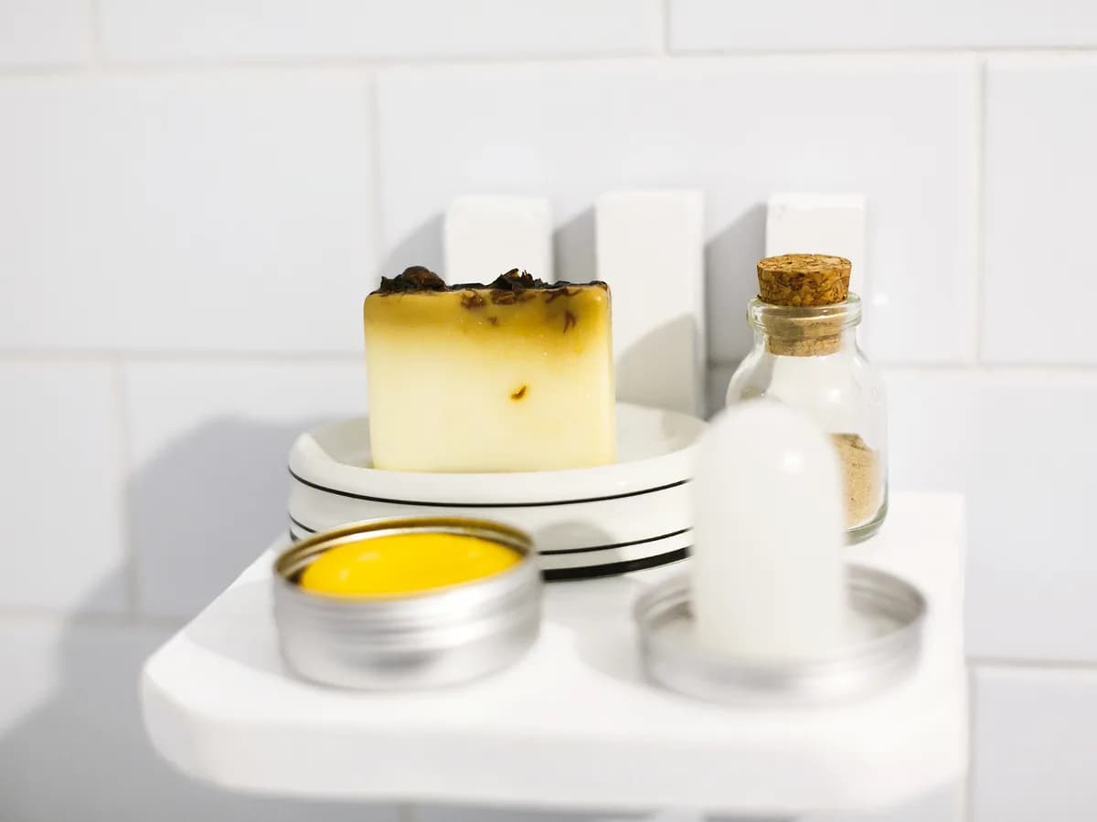 Handmade natural soap bar and skincare bottles styled on a bathroom shelf